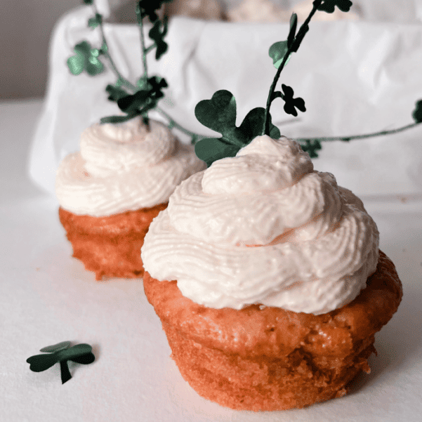 Zitronen-Cupcakes mit cremigem Frischkäse-Topping und kleinen grünen Kleeblättern als Silvester-Dekoration.